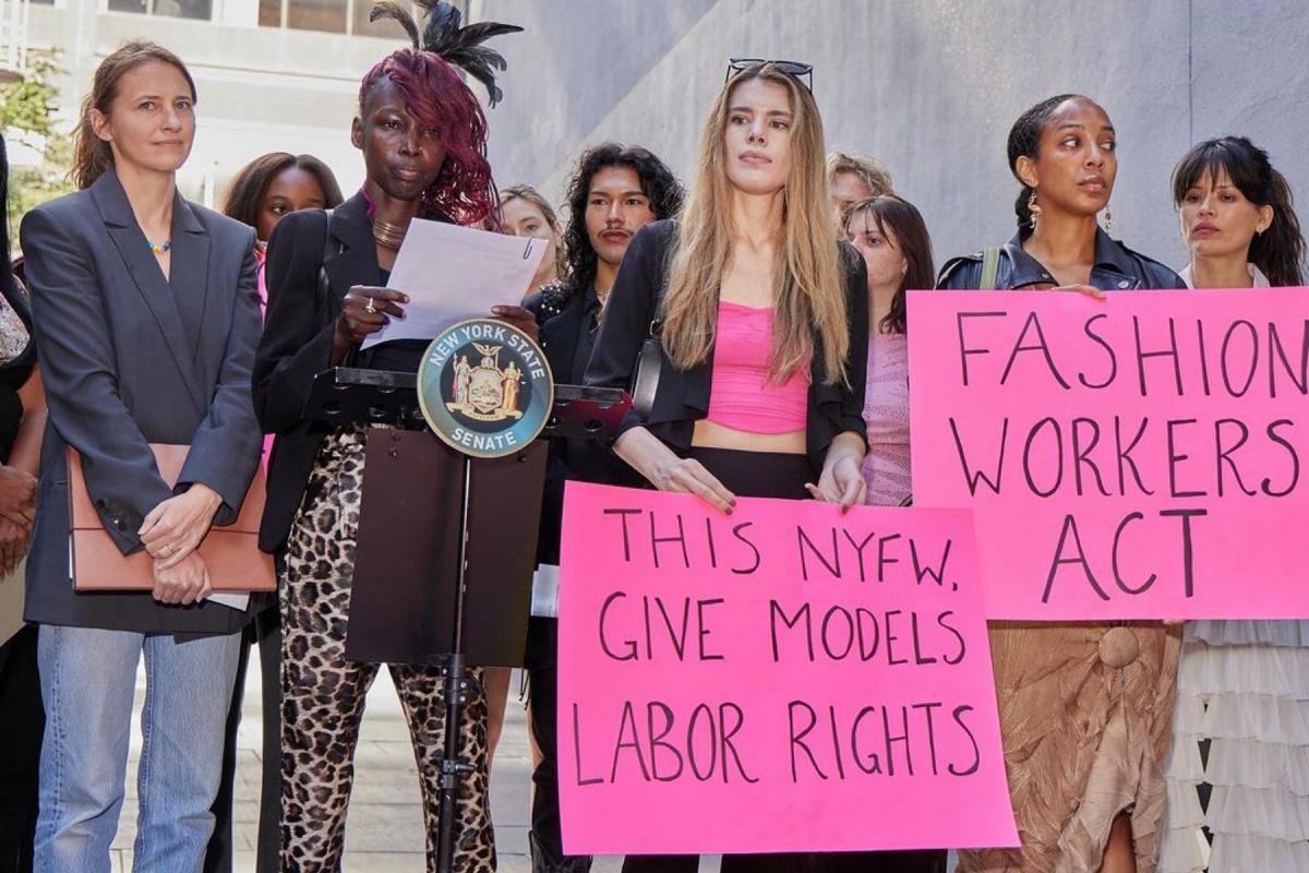 Modelos protestam na cidade de Nova York com cartazes rosa com reivindicações escritas em preto - Metrópoles