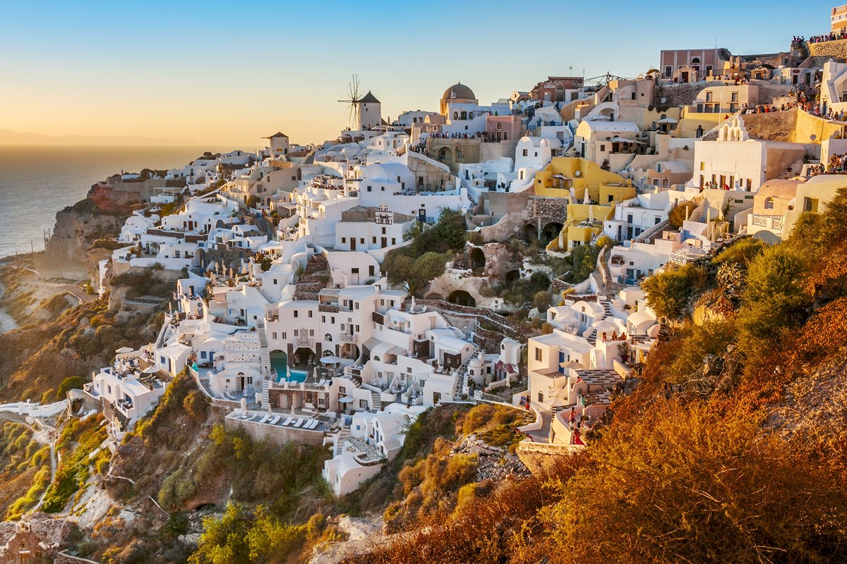 Foto colorida - Ilha Santorini, na Grécia. O local é repleto de casinhas brancas e atrai turistas de toto o mundo anualmente 