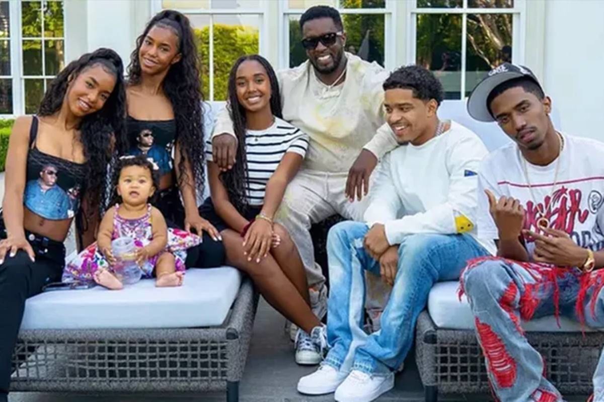 Imagem colorida de Sean Diddy Combs e seus sete filhos, sentados em sofá e sorrindo para a foto - Metrópoles