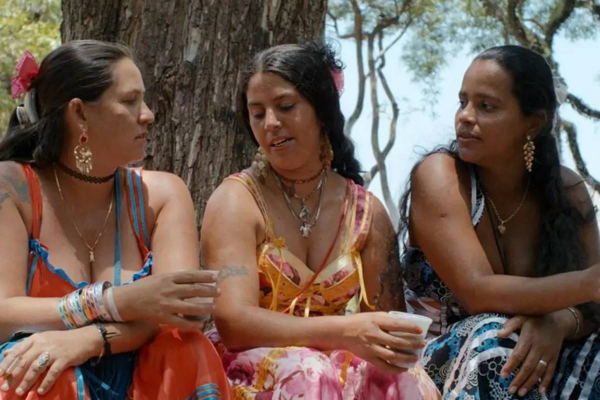 Imagem colorida do filme Terra de Ciganos mostra três mulheres conversando - Metrópoles