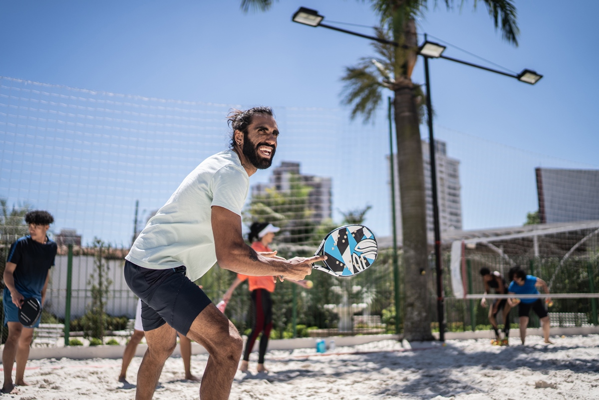 Homem adulto de meia idade jogando tênis de praia - Metrópoles