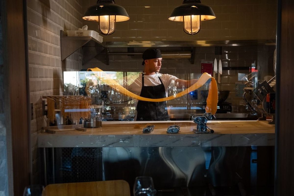 Foto colorida de uma chef de cozinha fazendo massa - Metrópoles