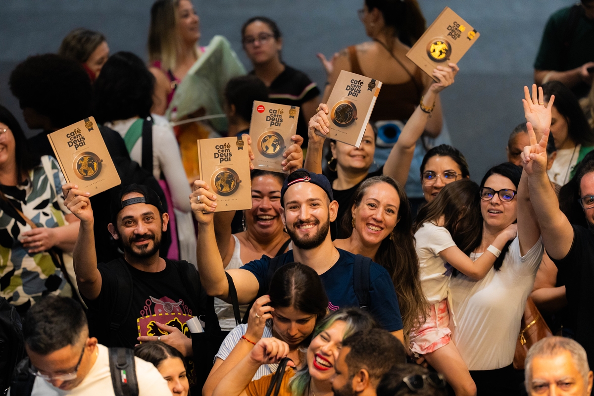 Pessoas segurando o livro Café com Deus Pai e sorrindo para a foto - Metrópoles