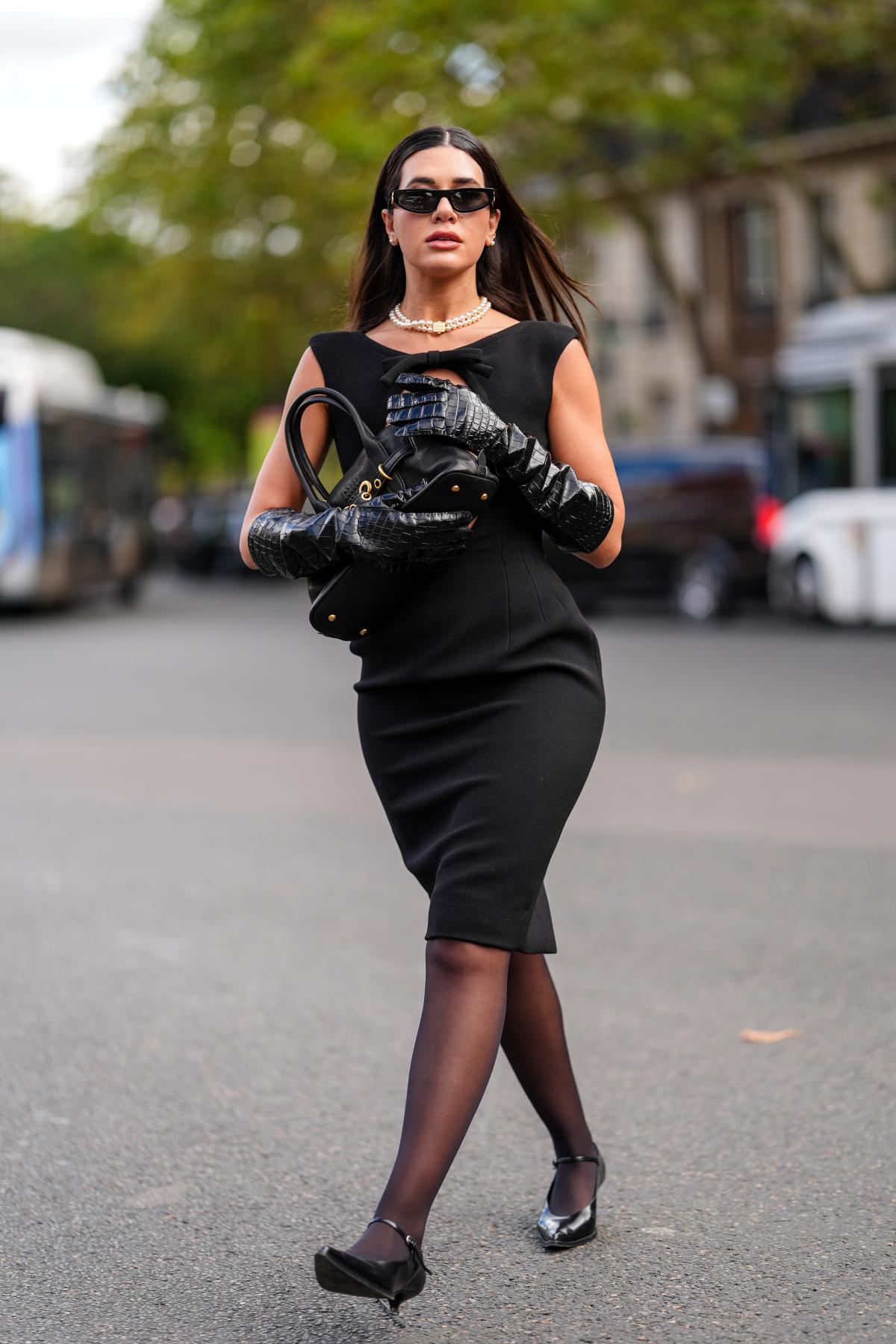 Dalam gambar berwarna, seorang wanita berpose untuk foto di Paris Fashion Week - kota metropolitan