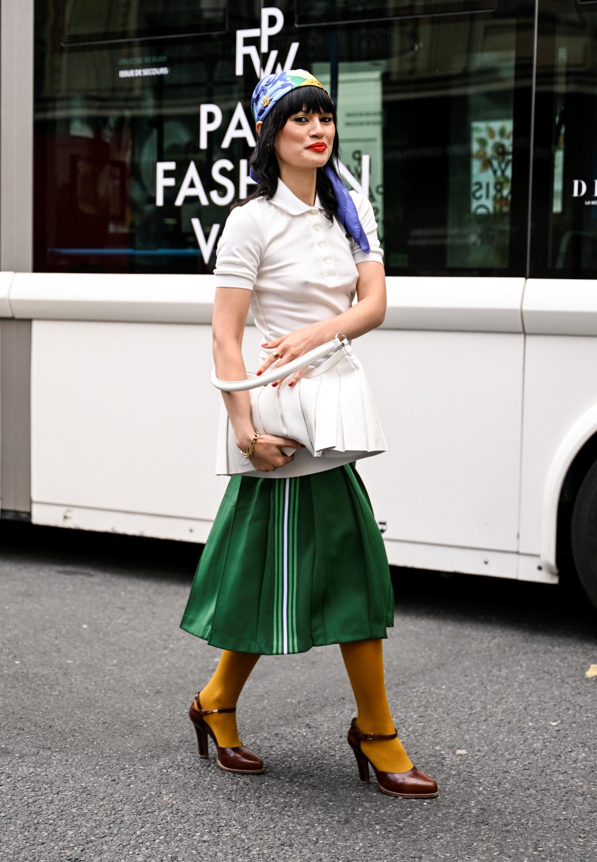 Dalam gambar berwarna, seorang wanita berpose untuk foto di Paris Fashion Week - kota metropolitan