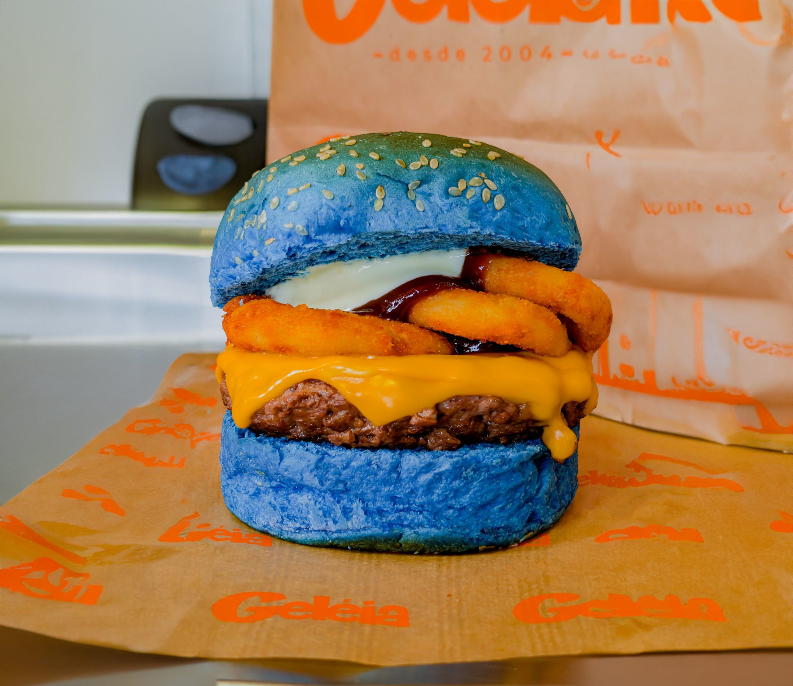 Na imagem colorida, um hambúrguer de carne com pão azul - Metrópoles 