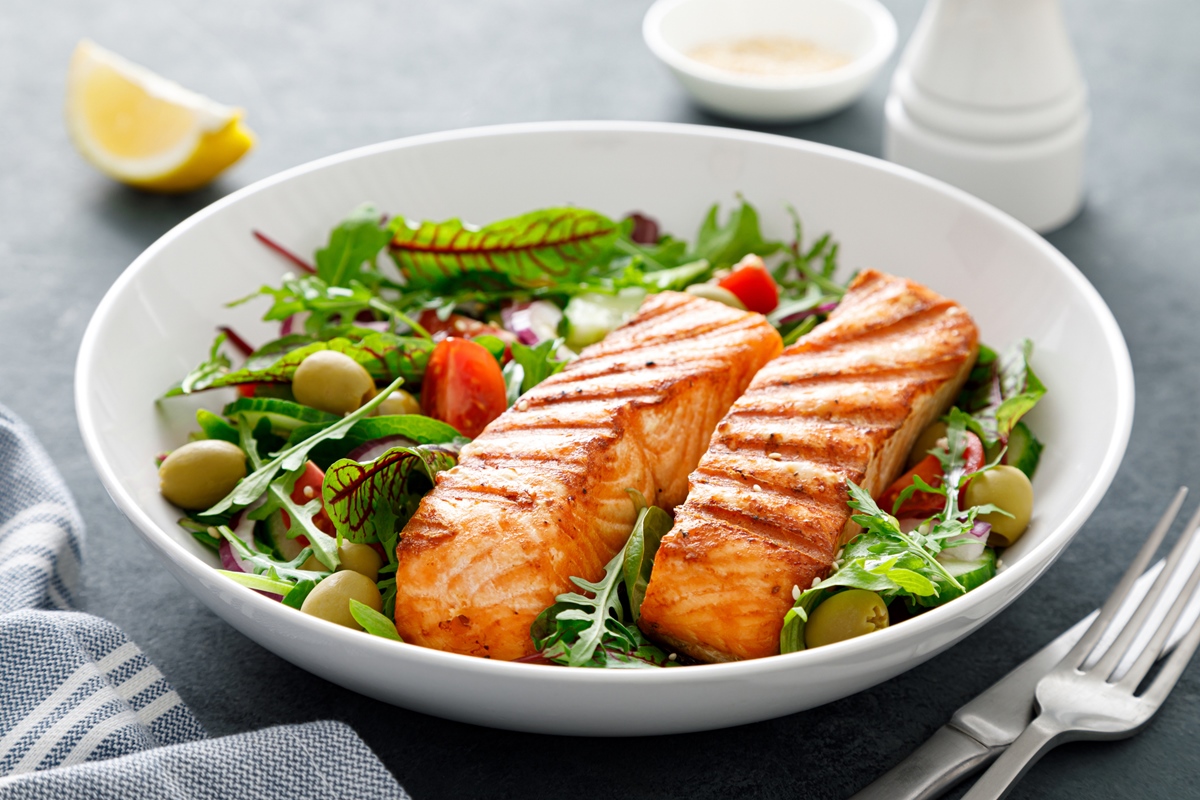 Filé de salmão grelhado e salada de legumes frescos. Dieta mediterrânea.