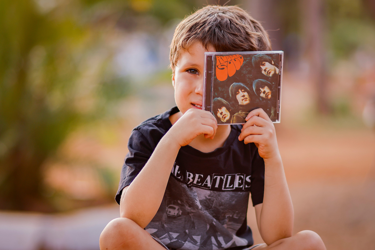 Foto colorida de uma criança com a blusa dos Beatles - Metrópoles