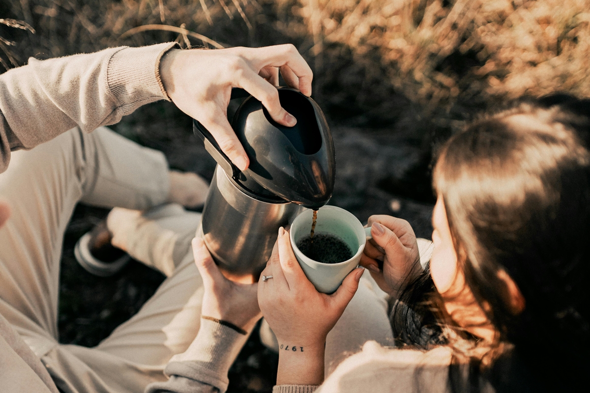 Duas pessoas tomando café ao ar livre - Metrópoles