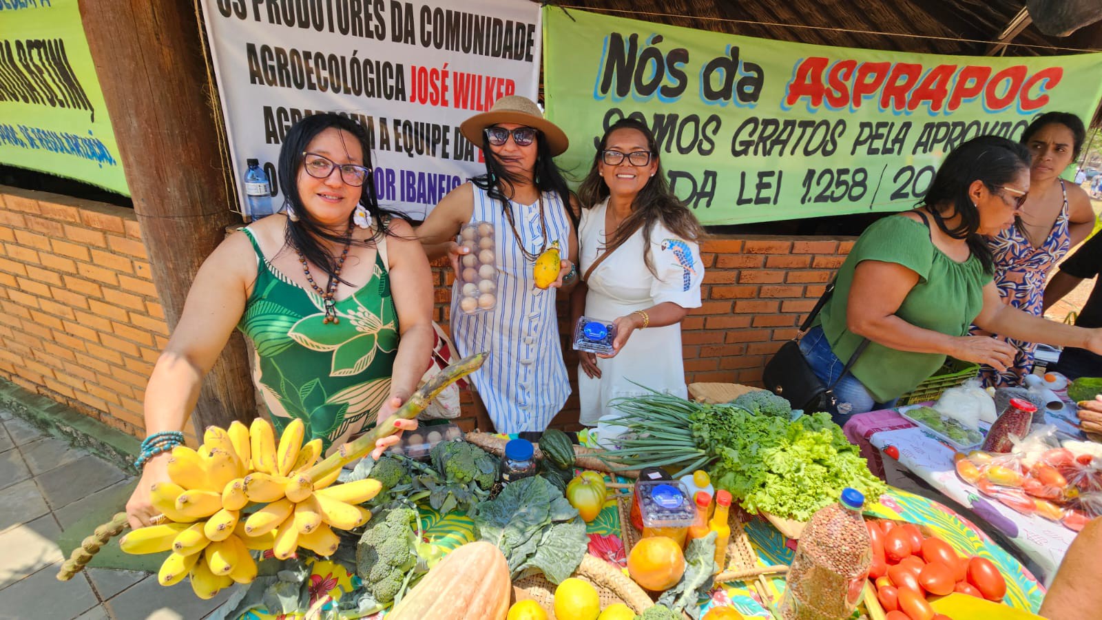 Fotografia colorida mostrando três mulheres feirantes com frutas e legumes em mesa-Metrópoles