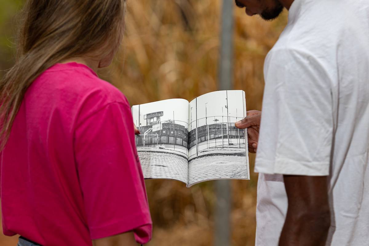 Imagem colorida de uma mulher e um homem segurando um livro