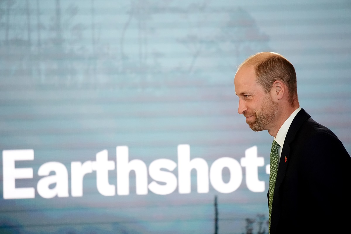 Foto de homem andando perto de backdrop com a palavra Earthshot - Metrópoles