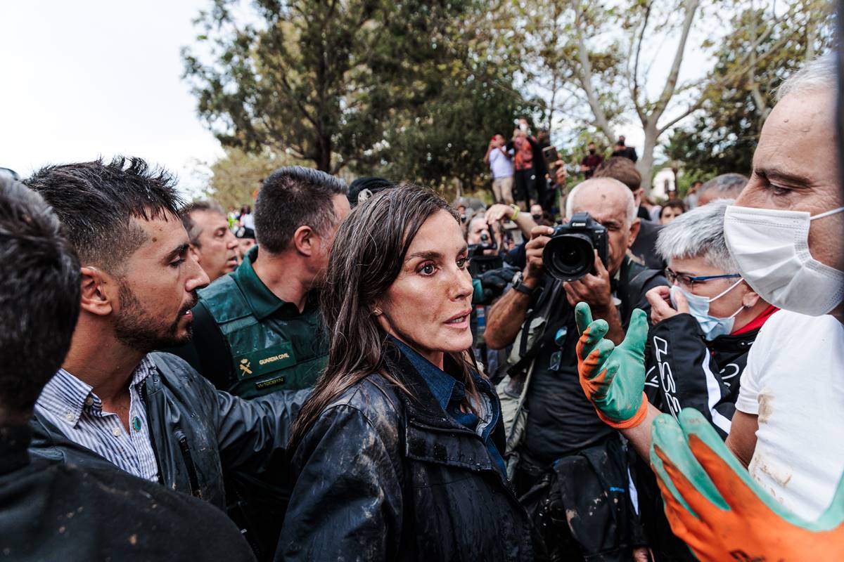 Foto colorida de pessoas com roupas sujas de lama - Metrópoles