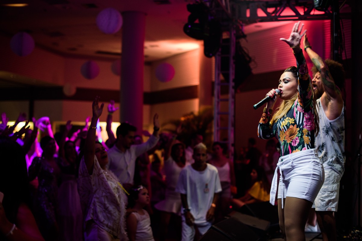 Fotografia colorida mostrando dois cantores em palco em frente à plateia-Metrópoles