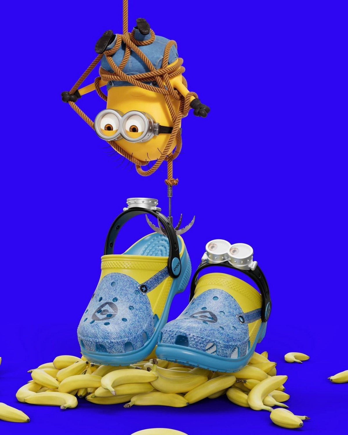 A imagem mostra um par de crocs temáticos do Minions sendo levantados por um gancho com um Minion