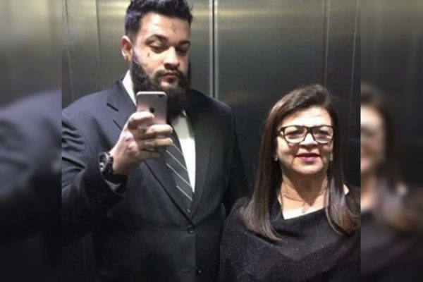 Imagem colorida, filho e mãe sorrindo em elevador - Metrópoles 