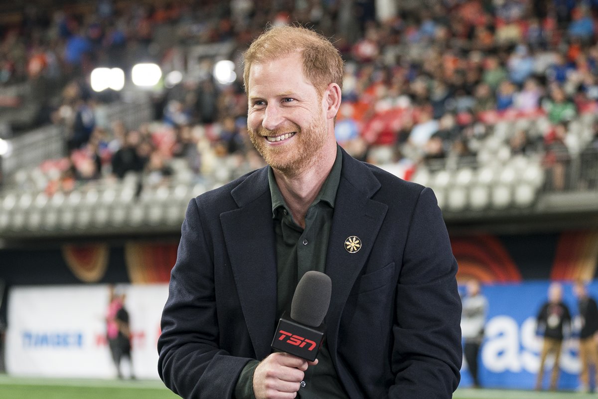 Foto colorida de homem segurando microfone e em estádio de futebol - Metrópoles