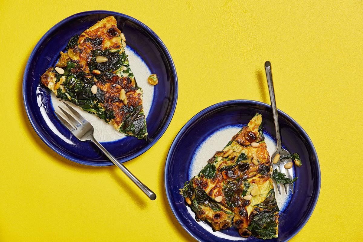 Foto colorida de ovos fritos com vegetais. O alimento está em frato - Metrópoles