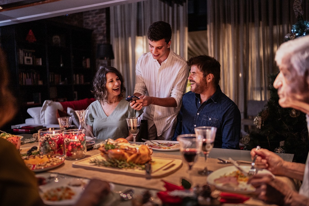 Foto colorida - Família em volta da mesa com ceia de Natal 