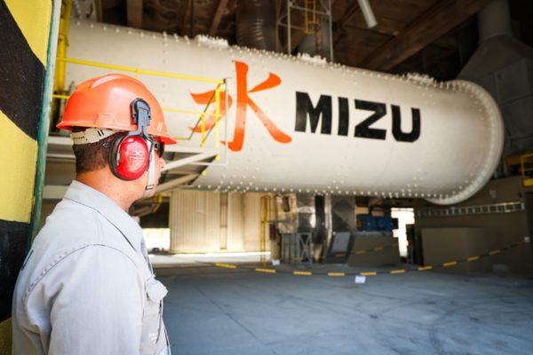 foto colorida de um homem de perfil, atrás de um tubo escrito Mizu - Metrópoles 