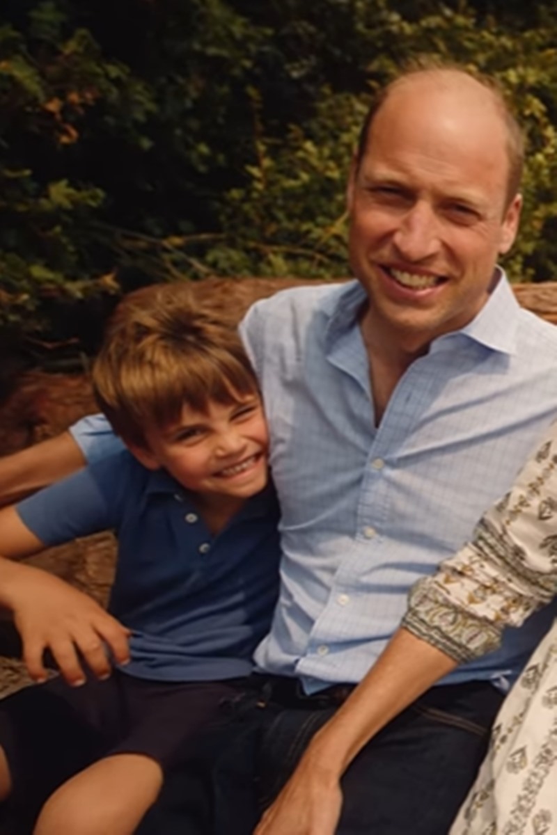 Foto colorida de menino e homem abraçados - Metrópoles