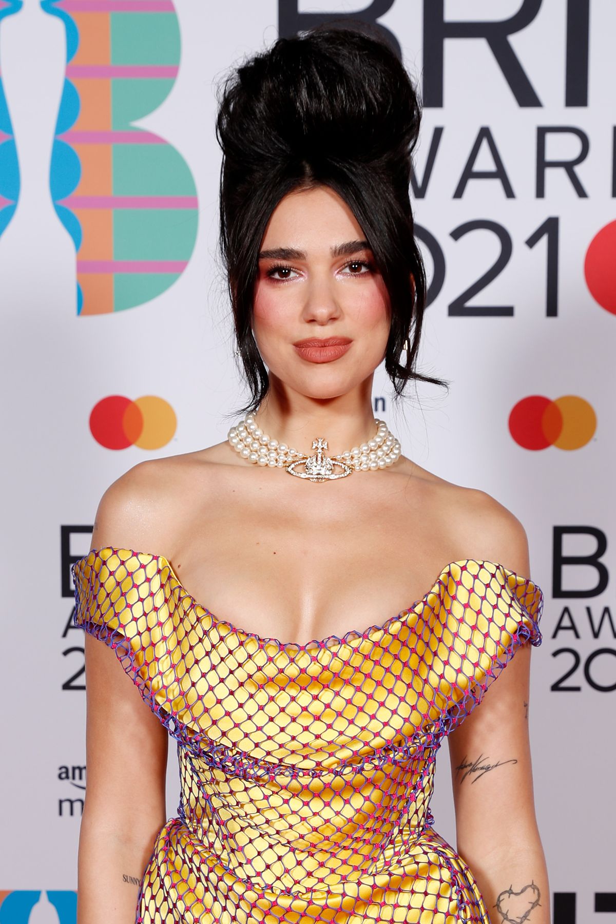 Dua Lipa usando colar de pérolas com o símbolo The Orb, da grife Vivienne Westwood - Metrópoles