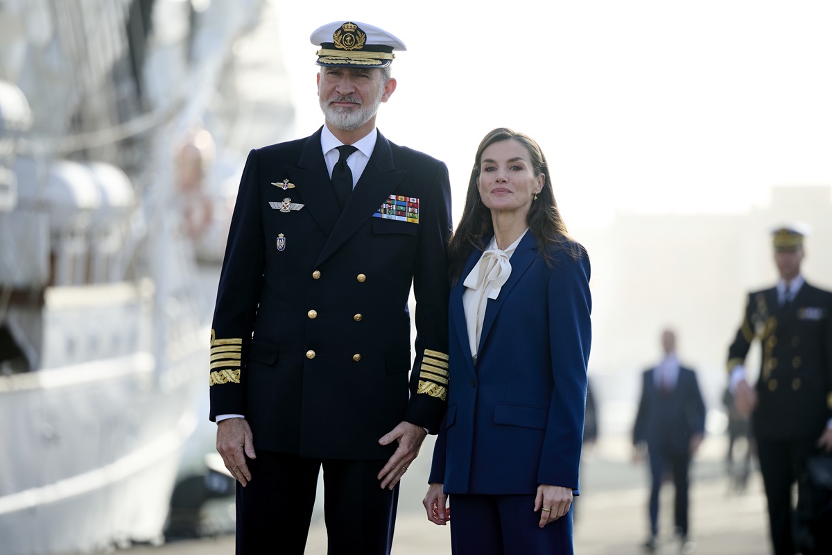 Foto colorida de homem com traje de marinheiro ao lado de mulher com terno azul - Metrópoles