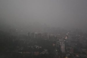 Céu escuro com chuva sobre vários prédios