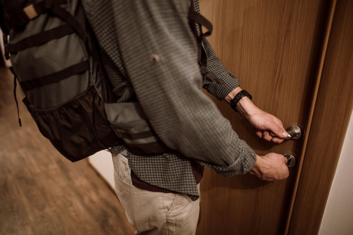 Foto colorida de um homem abrindo a porta - Metrópoles