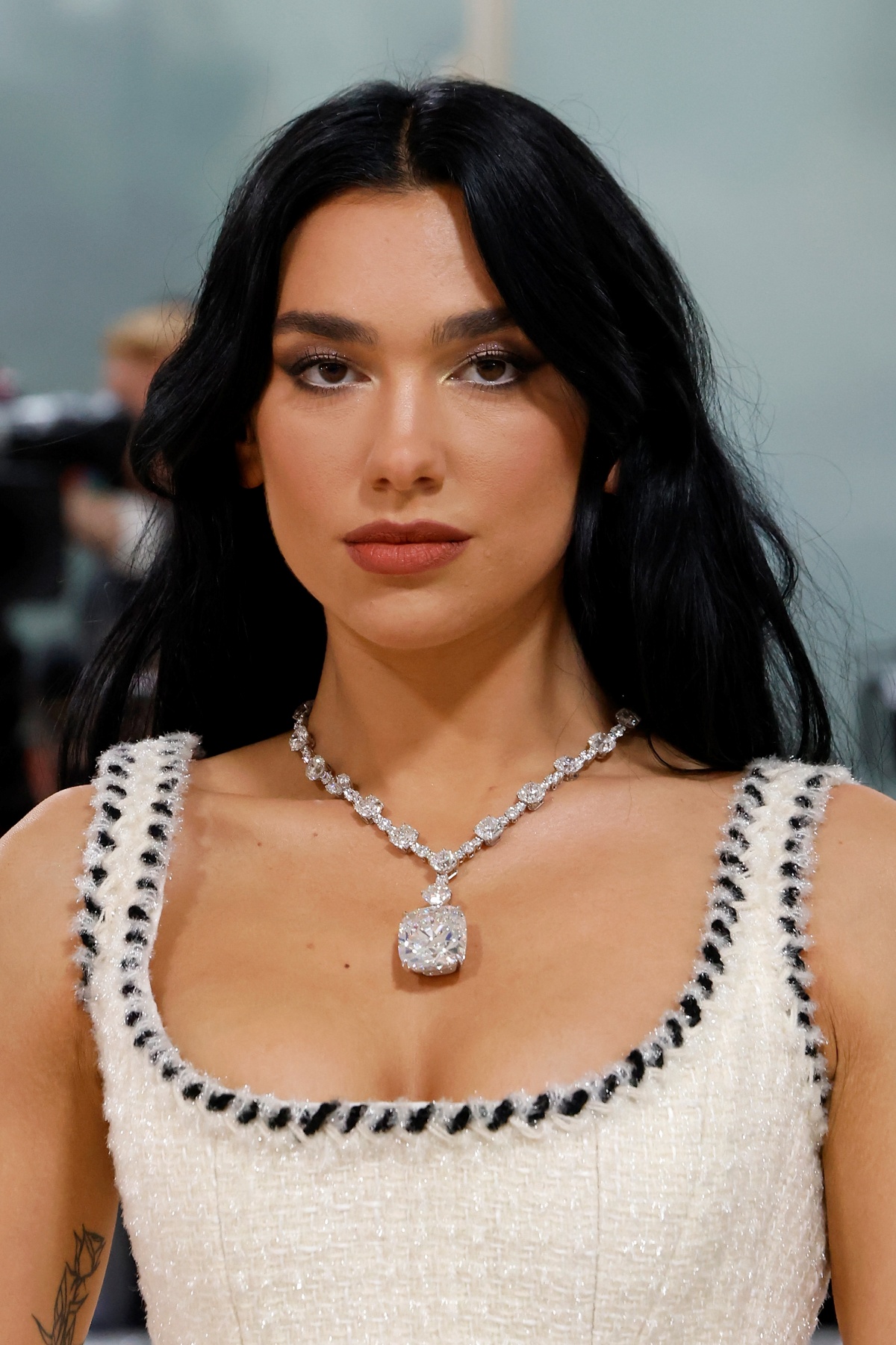 A imagem mostra a cantora Dua Lipa com uma joia da Tiffany & Co em seu pescoço.