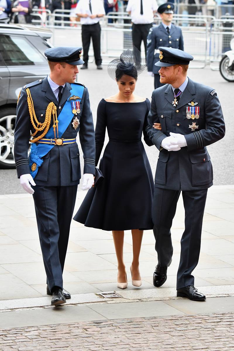 Foto colorida de dois homens com roupa militar. Entre eles, há uma mulher - Metrópoles