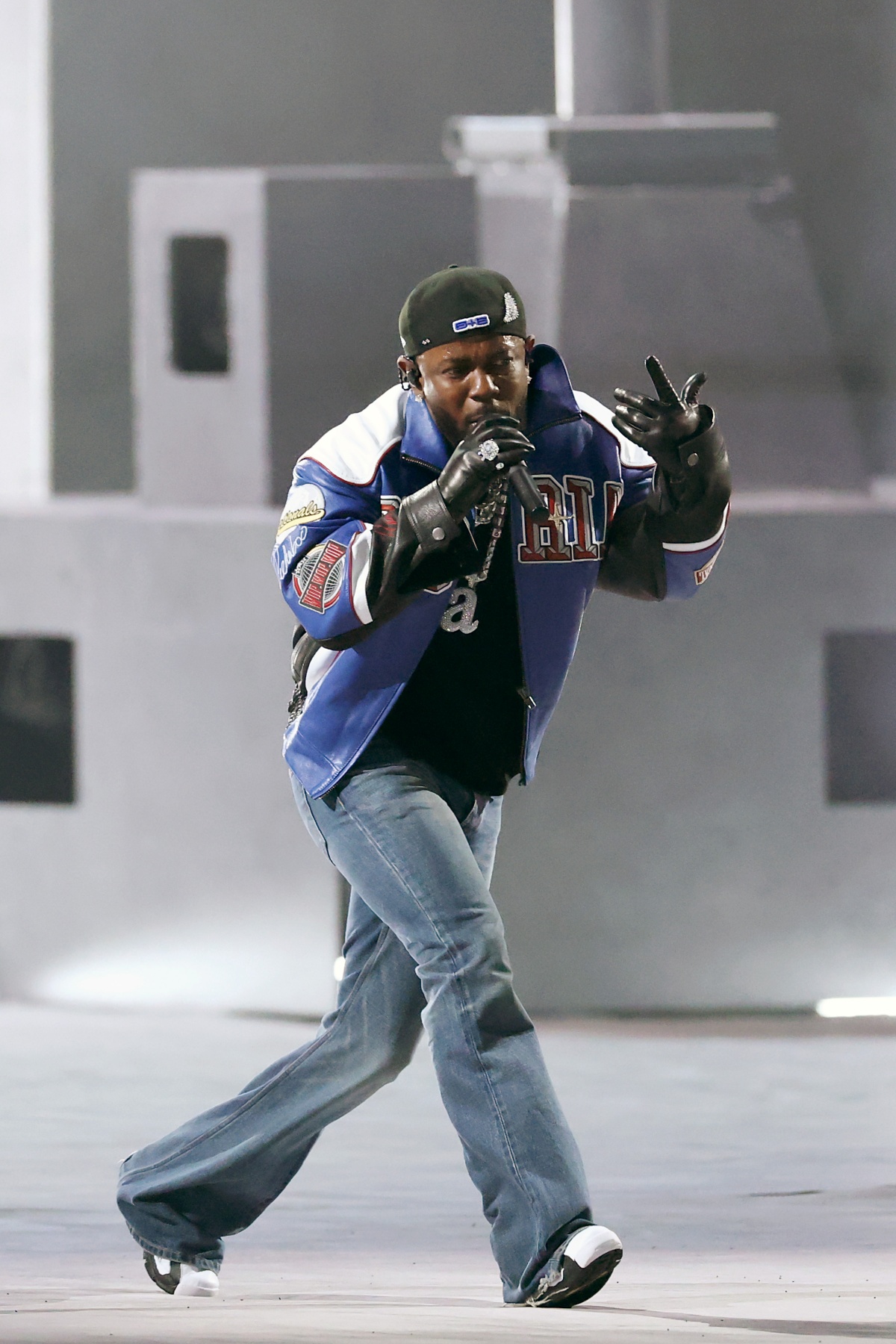 A imagem mostra o rapper Kendrick Lamar se apresentando no palco do Super Bowl LIX