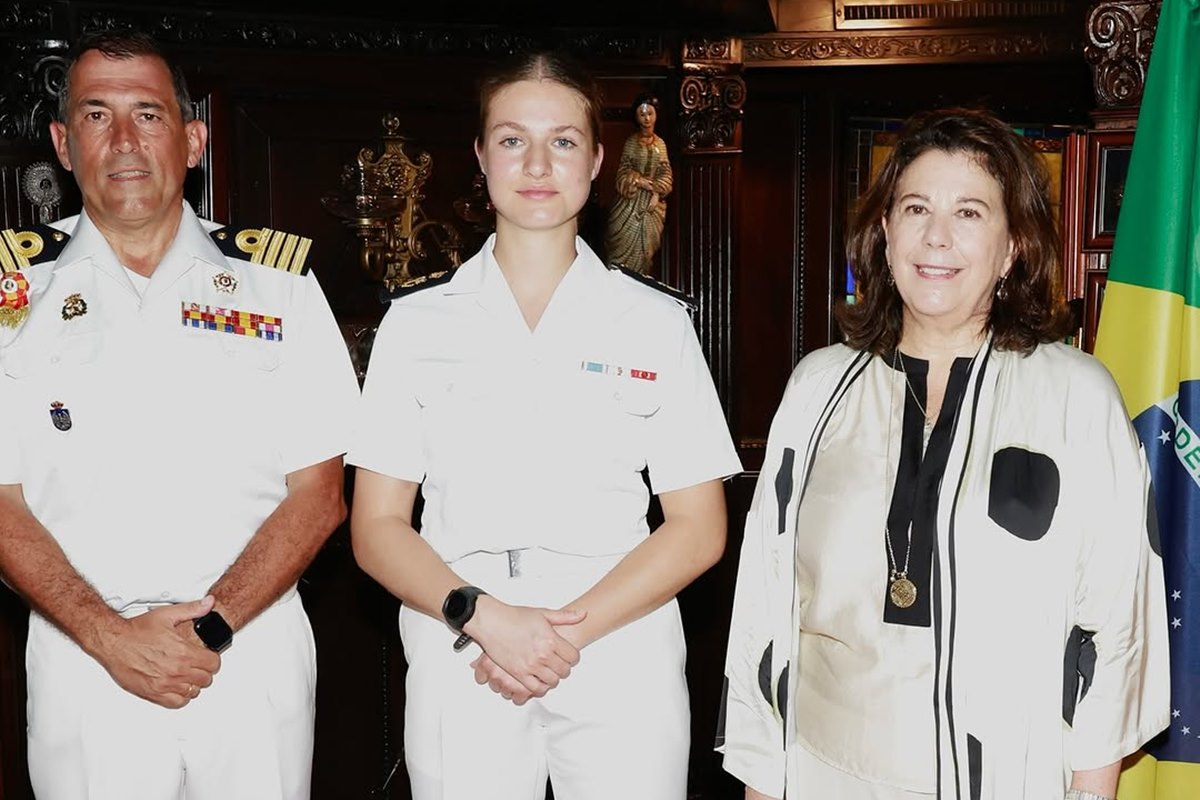 Foto colorida de três pessoas posando para uma foto. Duas delas estão com trajes da Marinha - Metrópoles