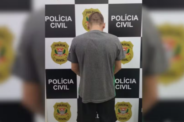 Imagem colorida mostra um homem de camisa cinza de costas sendo preso - Metrópoles