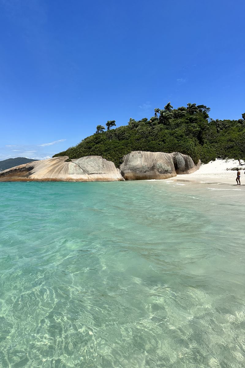 Foto colorida de praia com pedras gigantes - Metrópoles