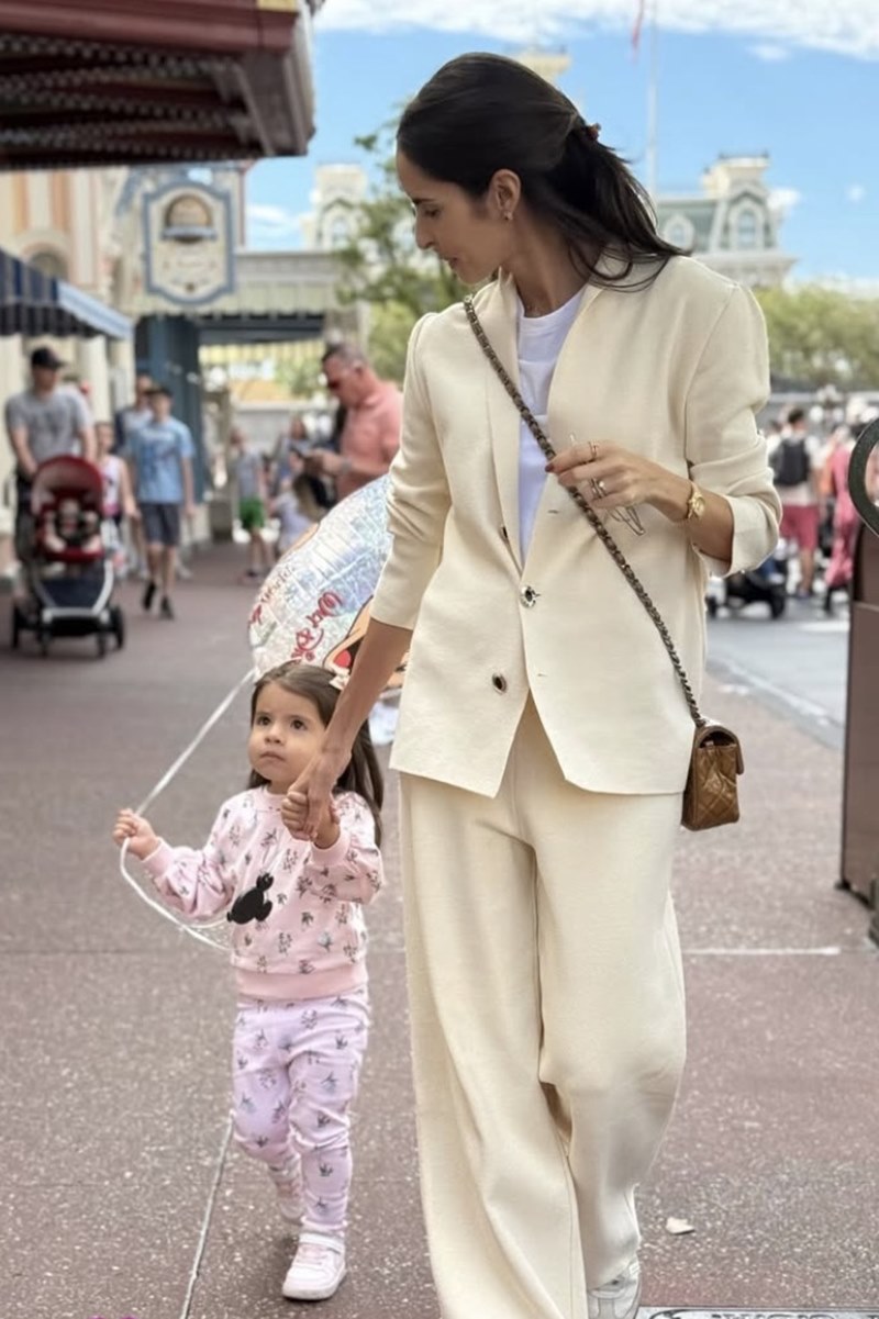 Foto colorida de menina segurando balão e de mãos dadas com mulher - Metrópoles