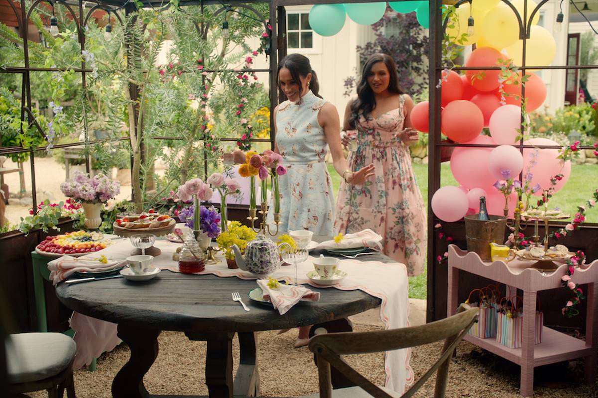 Foto colorida de duas mulheres entrando em um espaço decorado com balões - Metrópoles