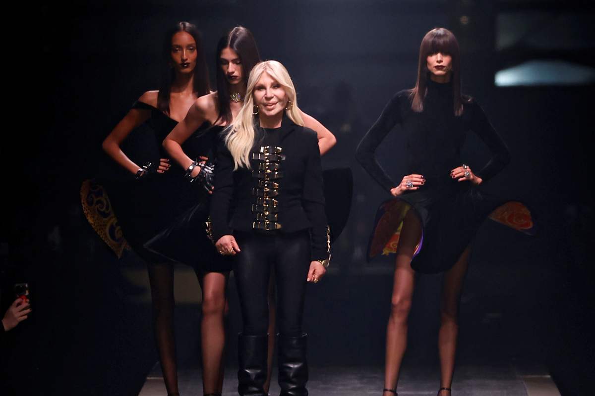 A imagem mostra a estilista Donatella Versace parada na passarela 