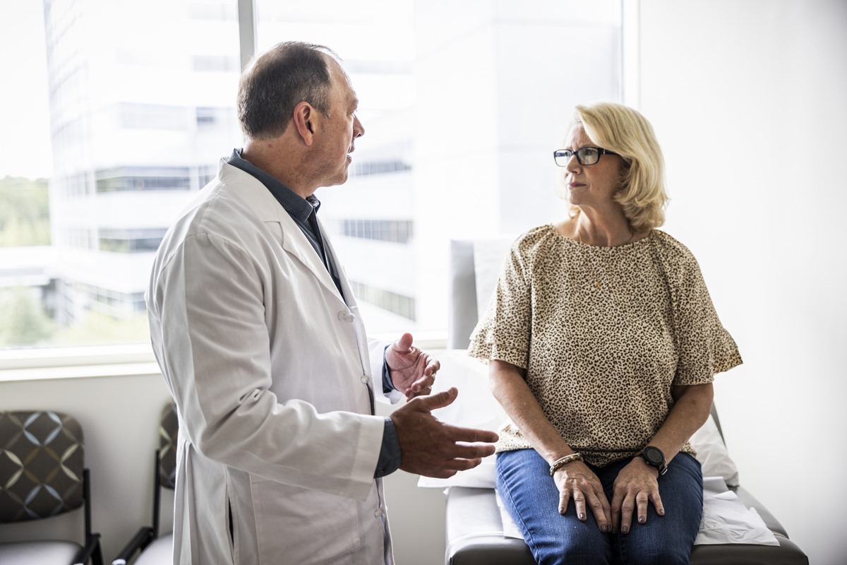 Médico sênior consultando uma mulher idosa na sala de exames - Diagnóstico com IA: entenda por que a supervisão médica é crucial