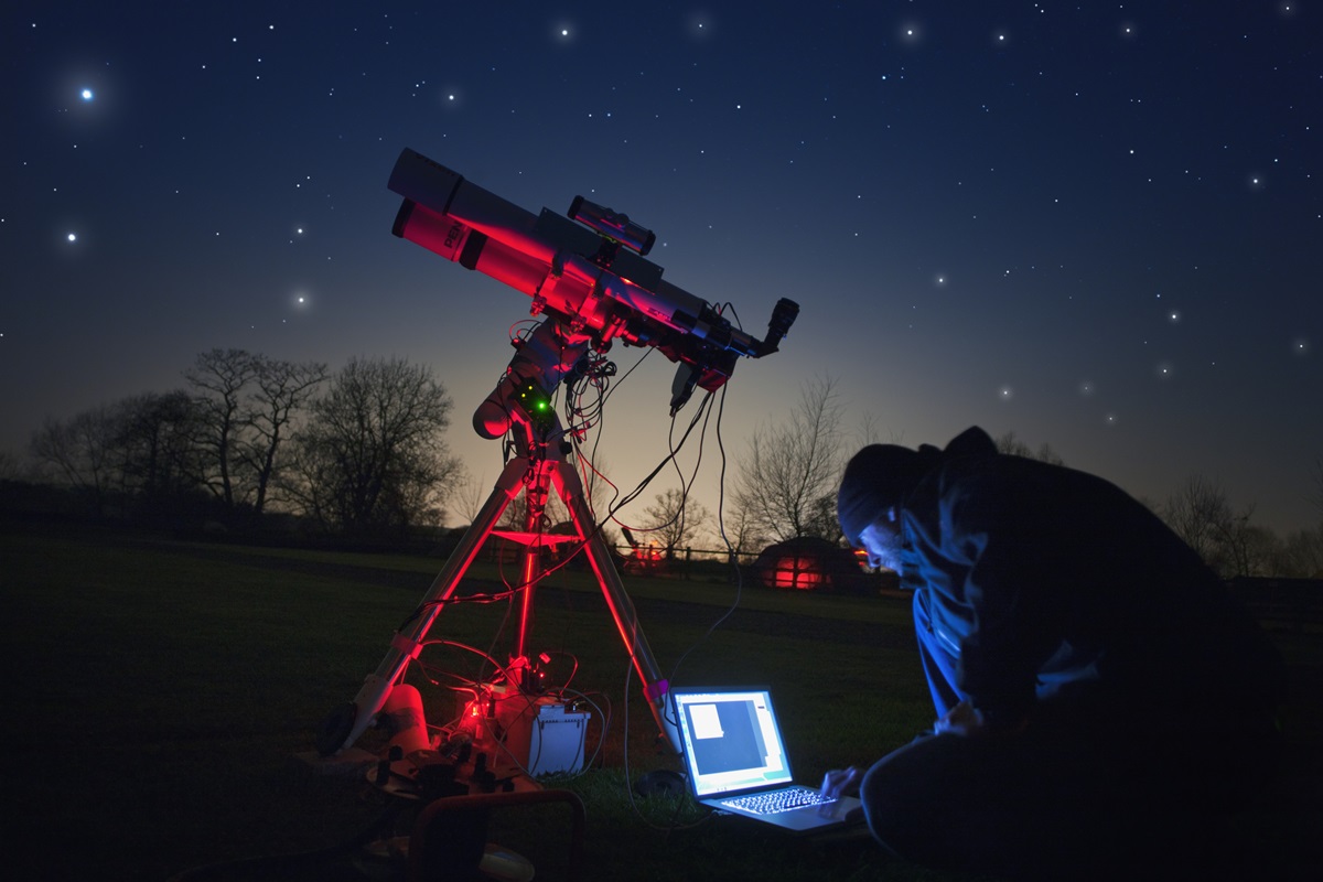 Imagem colorida de astronomo observando revelações de telescópio - Metrópoles