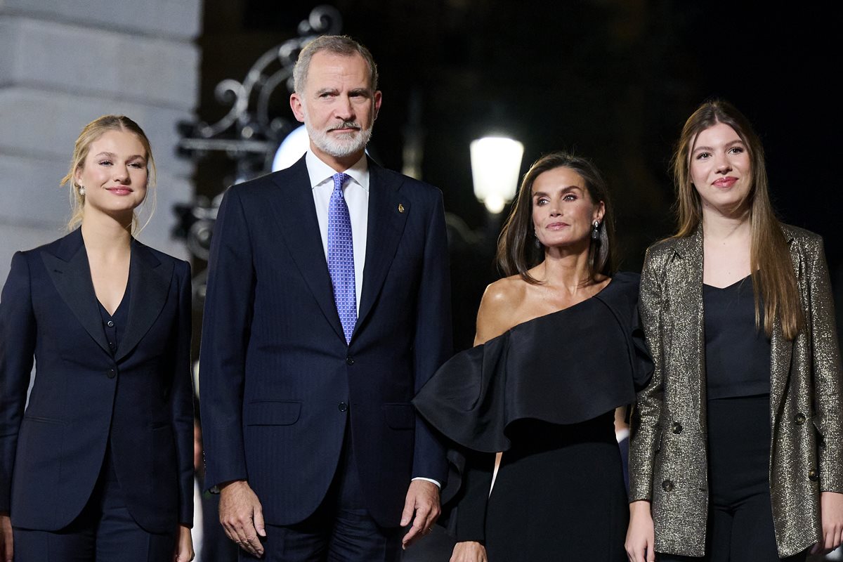 Foto colorida de três mulheres e um homem posando para fotos. Eles estão com roupas pretas - Metrópoles