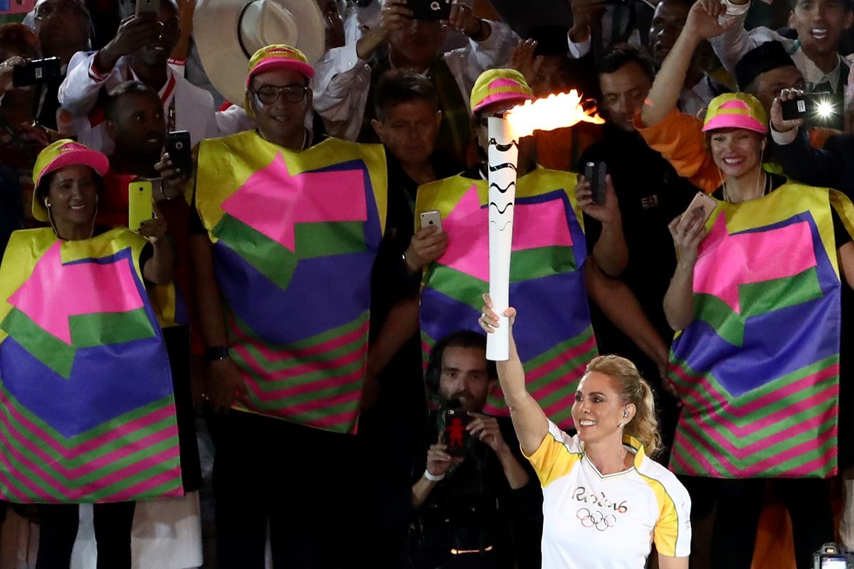 Foto colorida da atleta Hortência carregando a tocha olímpica nas Olimpíadas do Rio 2016 - Metrópoles