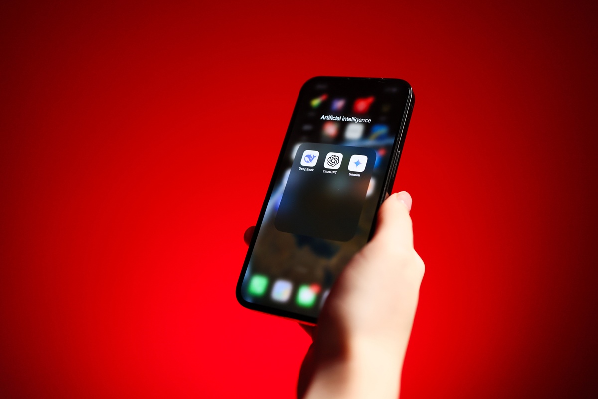 Mão segurando smartphone com aplicativos de assistente de IA de inteligência artificial - DeepSeek, Chat GPT, Google Gemini. Metrópoles