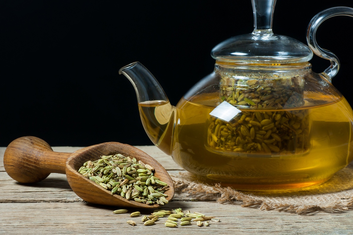 Chá de erva-doce com infusão de ervas em copo de vidro com sementes de erva-doce secas em uma pá de madeira. Conceito de fundo de medicina alternativa com chá de ervas