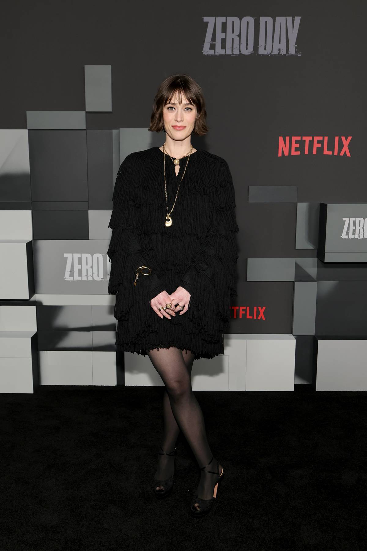 Lizzy Caplan com sandálias e meia-calça - Metrópoles
