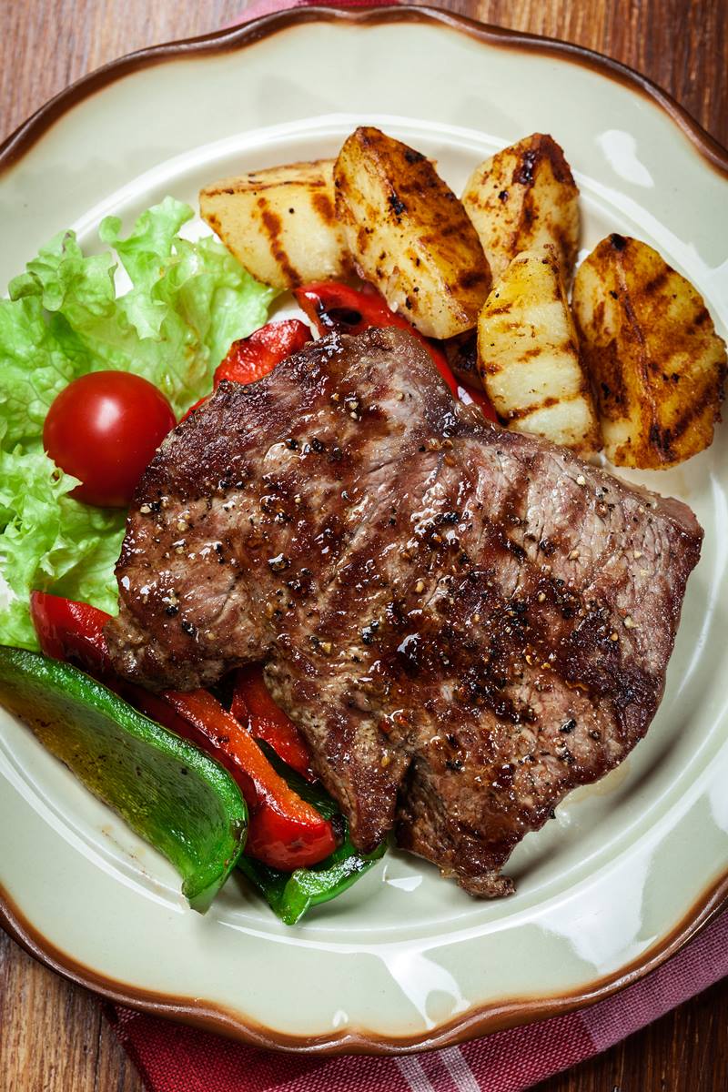 Foto colorida de bife em prato, com salada e fritas - Metrópoles