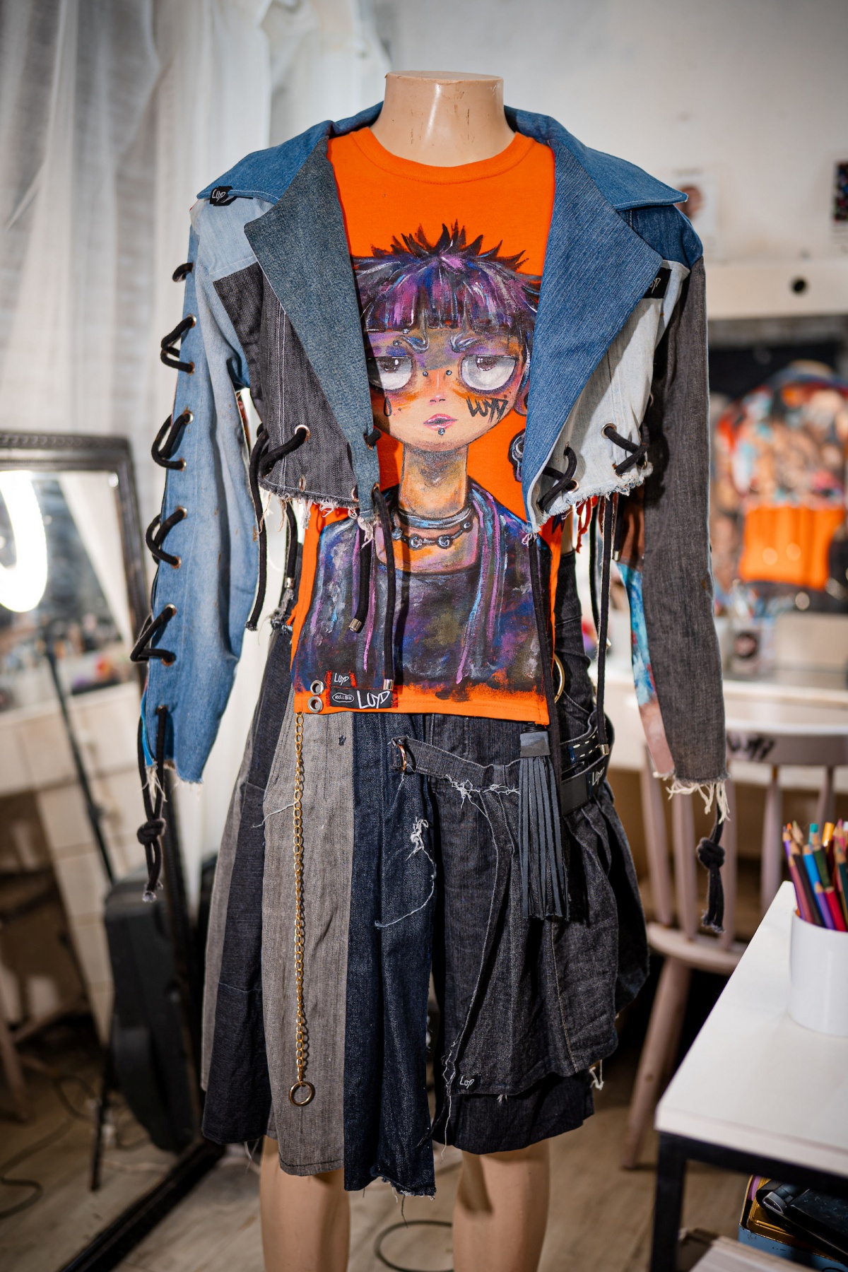 A imagem mostra um look de jaqueta e saia em jeans