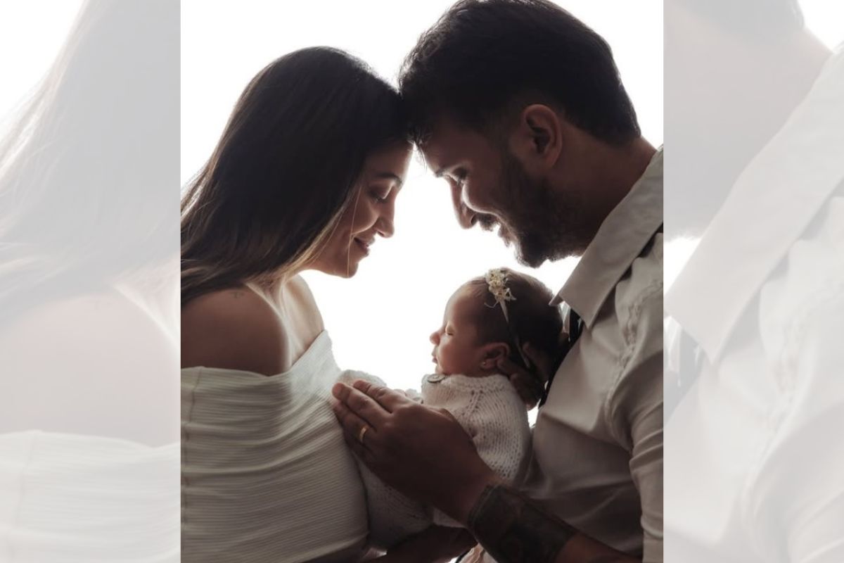 foto colorida de casal com filha recém nascida