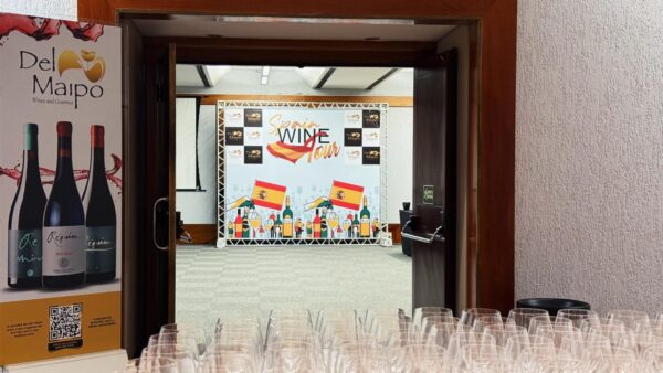 Fotografia colorida mostrando mesa e painel de evento de degustação de vinho-Metrópoles