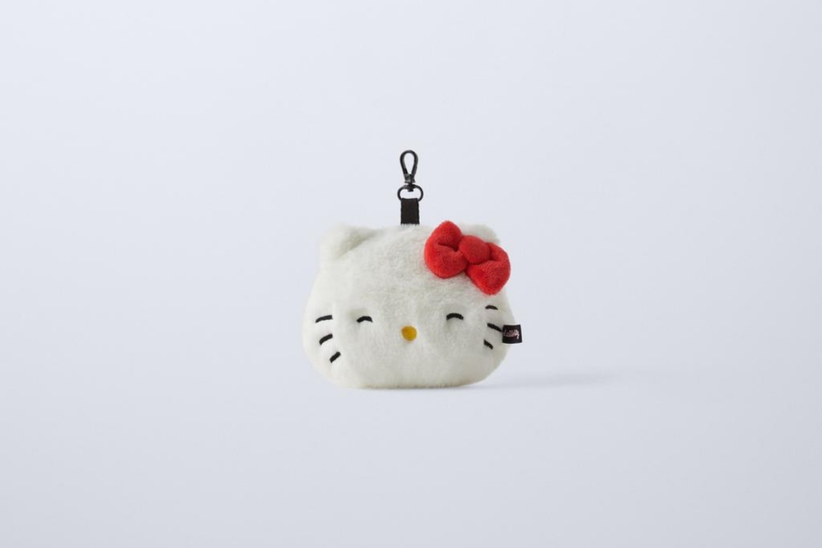 A imagem mostra um charm da boneca Hello Kitty em um fundo branco
